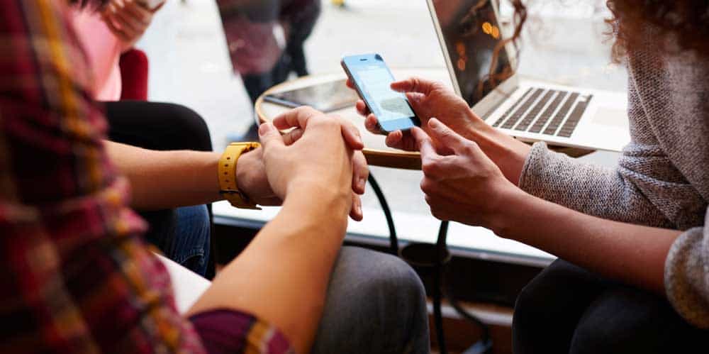 woman shows online mobile shopping to friends
